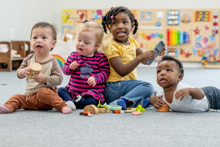 early years children playing on the carpet with toys 